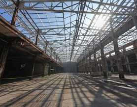 Inside view of large industrial building, with rafters open to the sky